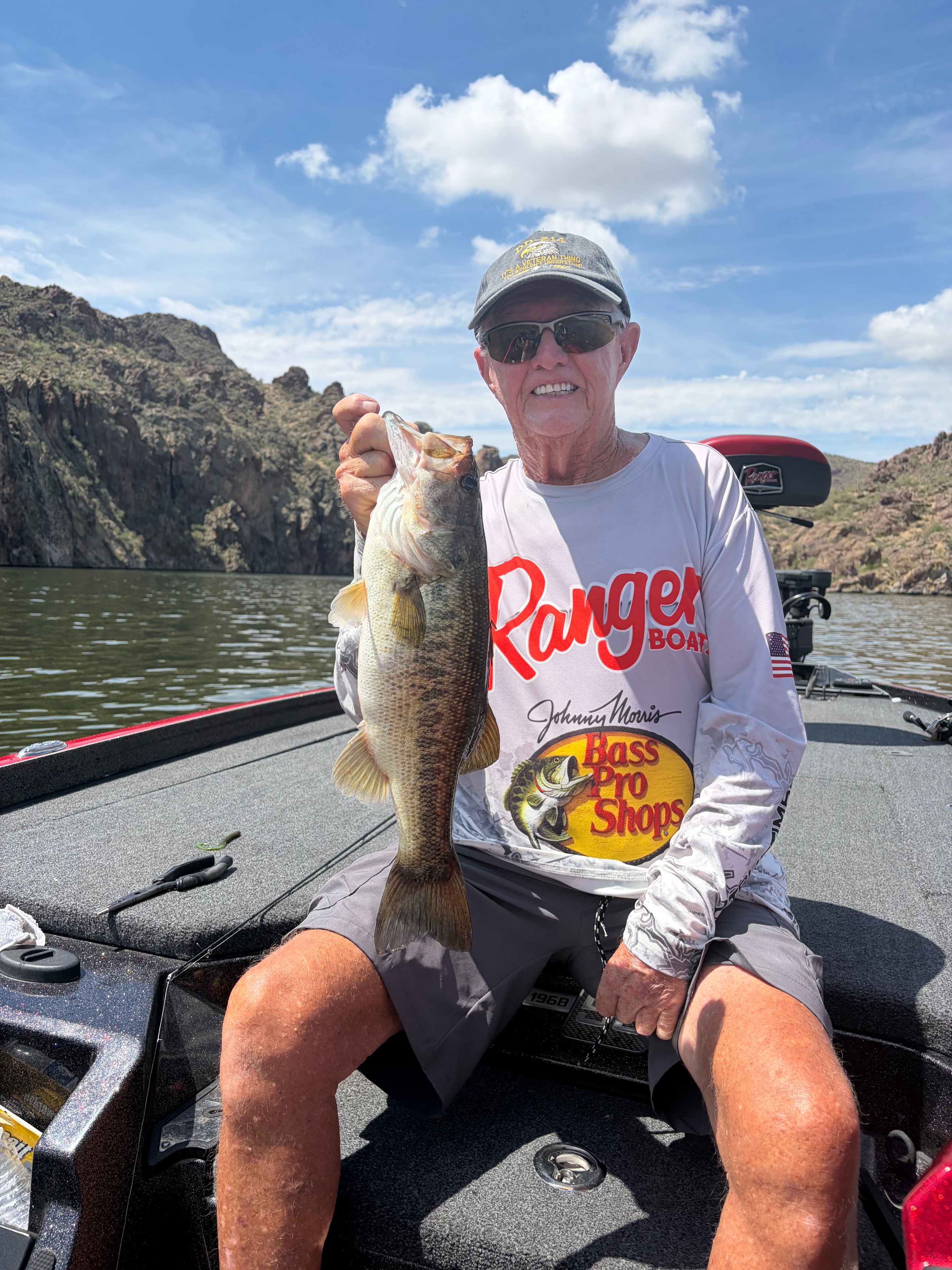 Man holding large bass on fishing boat