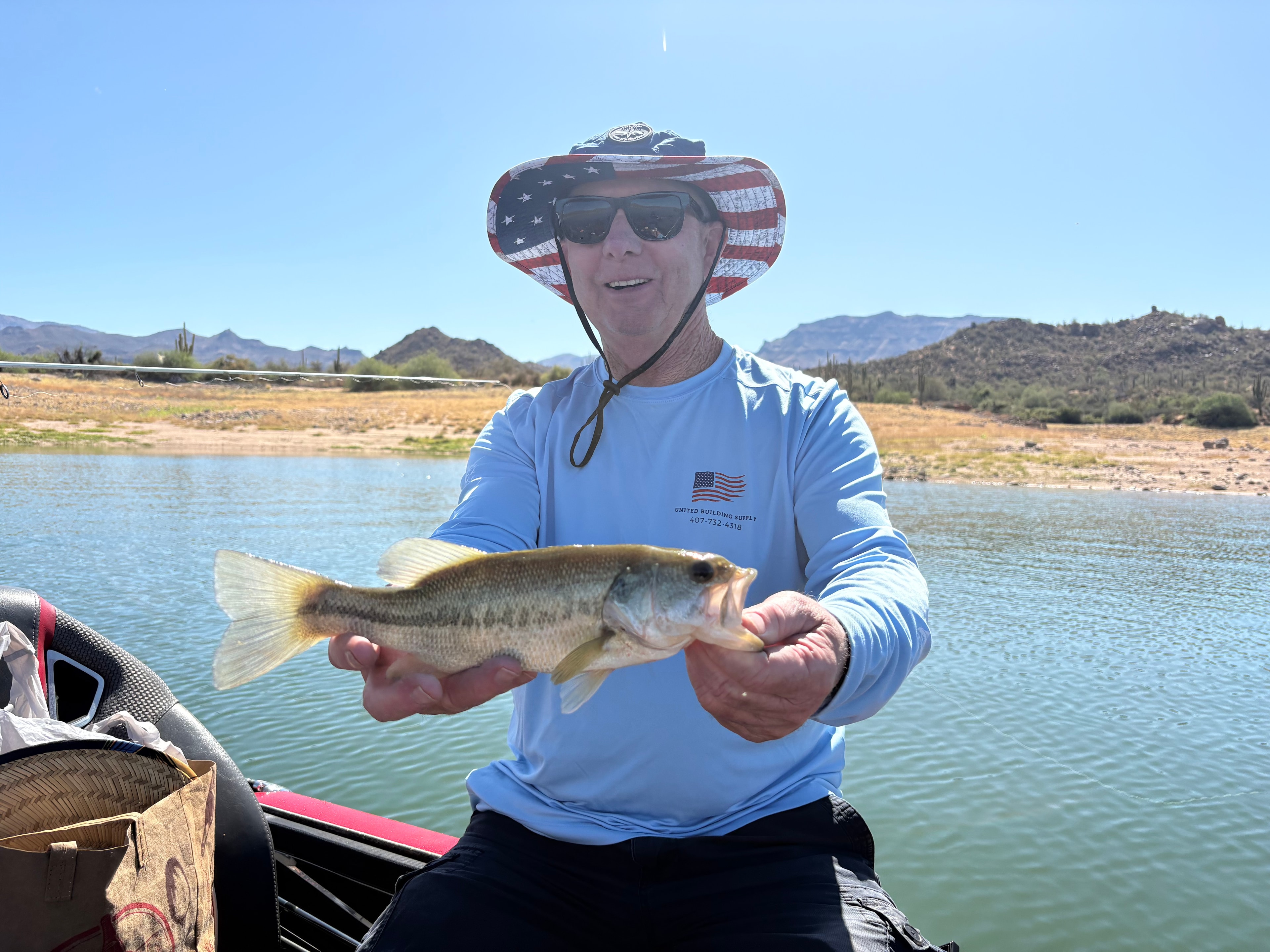 Man holding caught fish at desert lake